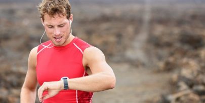 running athlete man looking at heart rate monitor gps watch
